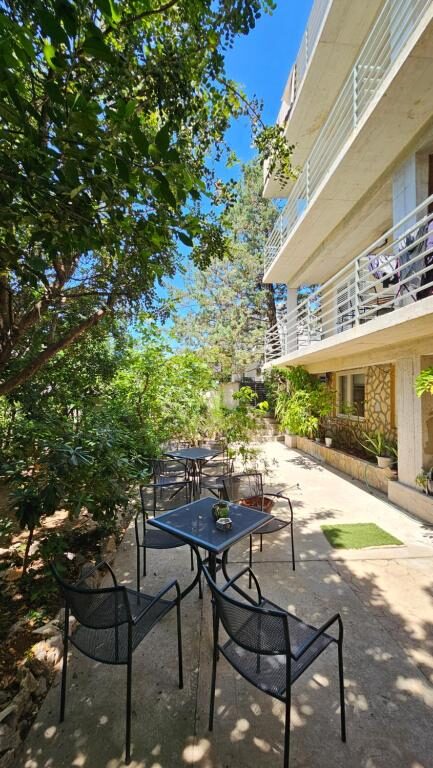 Garden terrace with tables and shade at Bed & Breakfast Dora